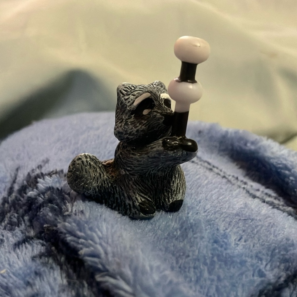 Gray Raccoon Figurine with marshmallows on a stick
